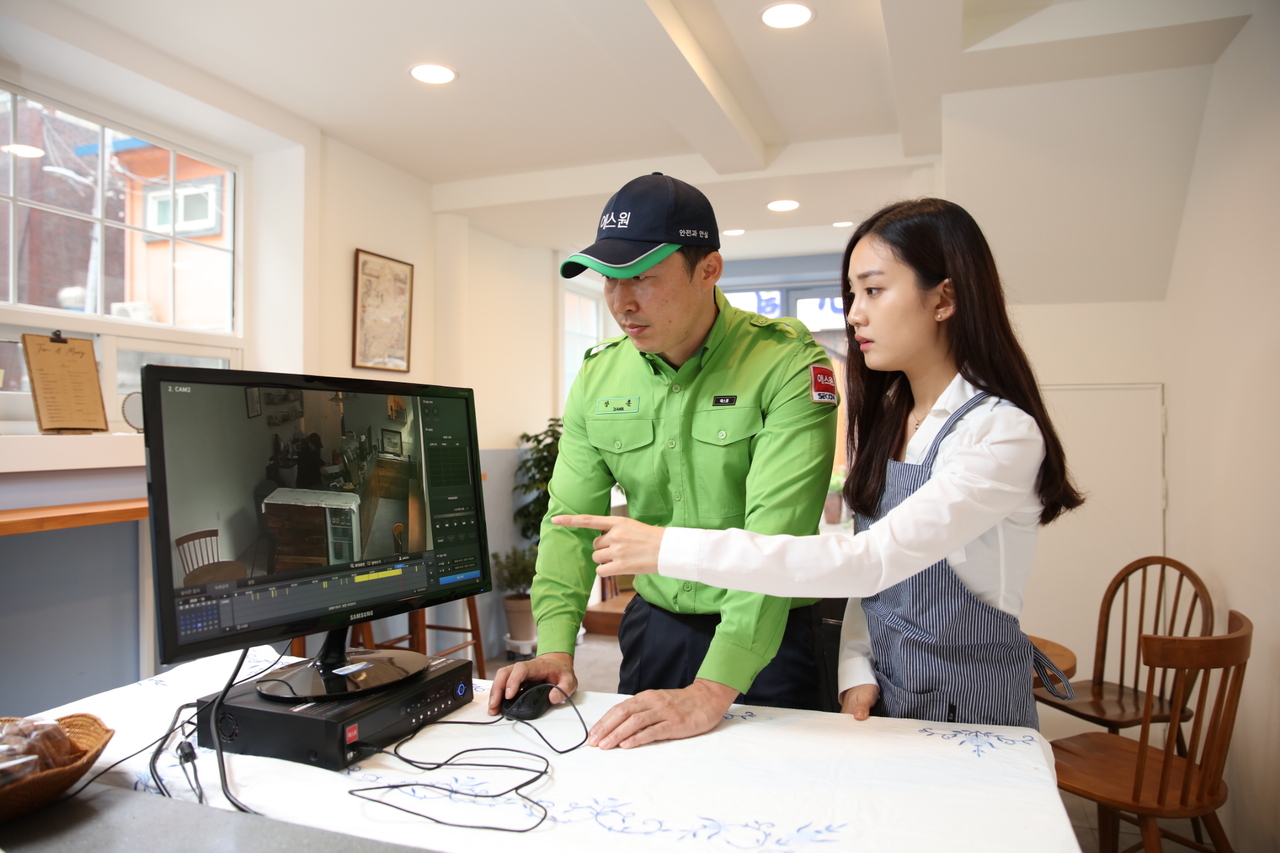 An S-1 security officer explains how to review surveillance footage to the owner of an unmanned store. (S-1 Corporation)