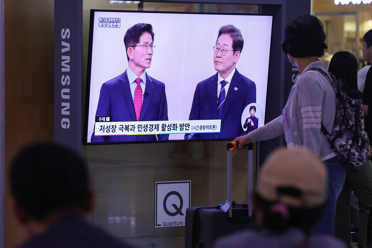 18일 서울역 대합실에서 시민들이 제21대 대선 1차 후보자 토론회 중계방송을 지켜보고 있다. [연합]