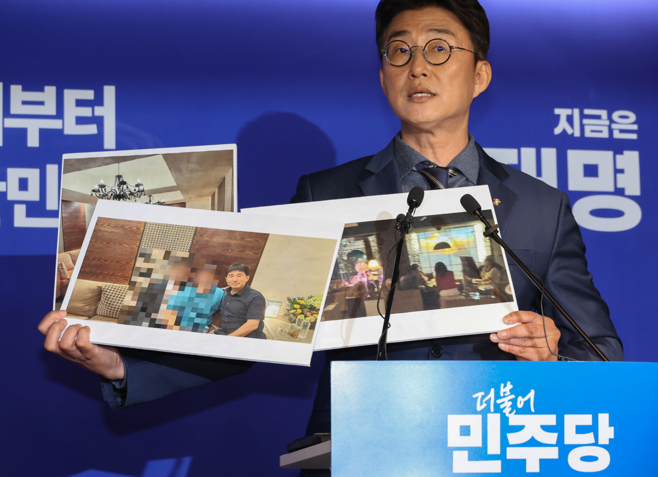 Spokesperson Noh Jong-myun of the Democratic Party of Korea reveals undated photos of Judge Jee Kui-youn, allegedly at a hostess bar in Gangnam-gu, central Seoul, during a press briefing held at the party’s headquarters on Monday. (Yonhap)