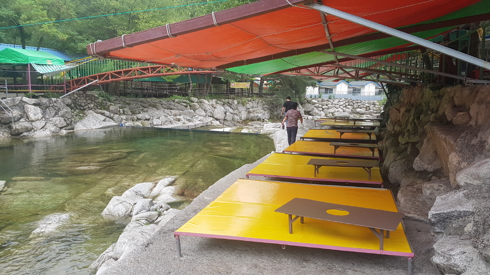 This undated photo, unveiled in August 2019, showed unlicensed business set up along a mountain stream in Gyeonggi Province. (Gyeonggi Province)