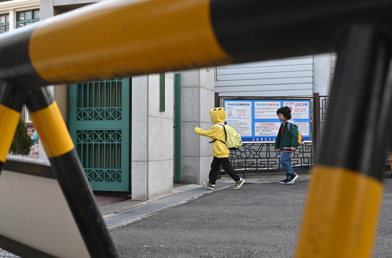 Students enter the grounds of an elementary school in Seoul on March 14. (Im Se-jun/The Korea Herald)