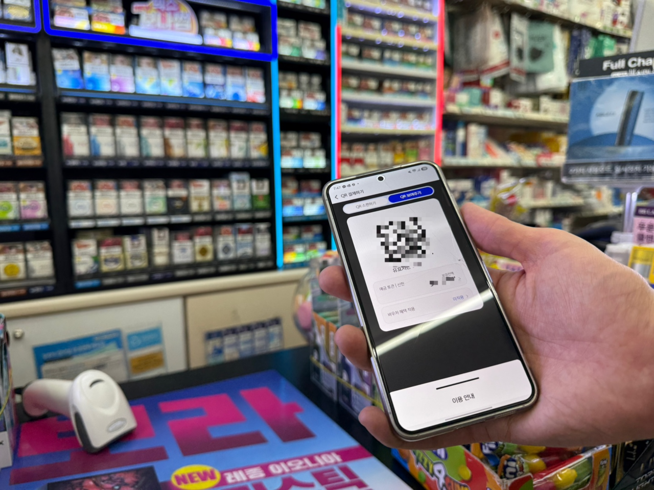 A mobile phone displays a CBDC payment QR code at a 7-Eleven checkout in Seoul on Monday. (Choi Ji-won/The Korea Herald)