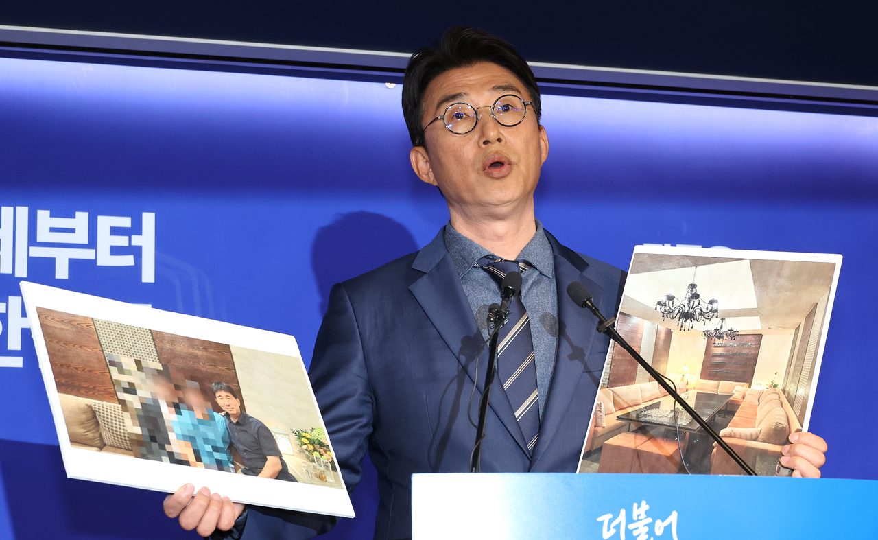 Rep. Noh Jong-myeon, a spokesperson for the Democratic Party's election committee, discloses photos at the party's headquarters in Seoul on Monday. (Yonhap)