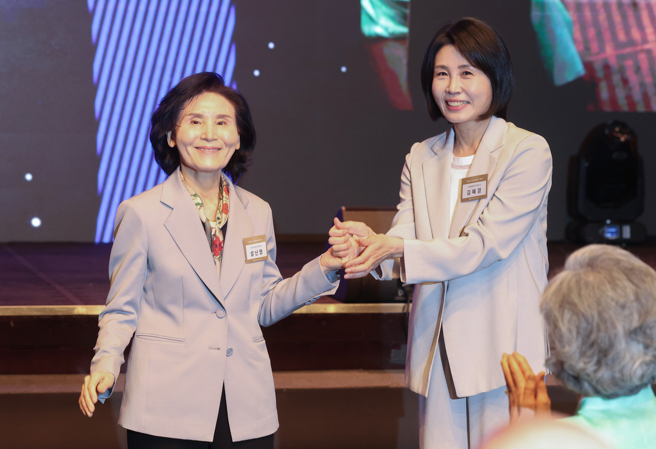 김문수 국민의힘 대선 후보의 부인 설난영 씨와 이재명 더불어민주당 대선 후보의 부인 김혜경 씨가 지난 12일 서울 중구 신라호텔에서 열린 중앙신도회 창립 70주년 기념식에서 손을 맞잡고 있다. [연합]