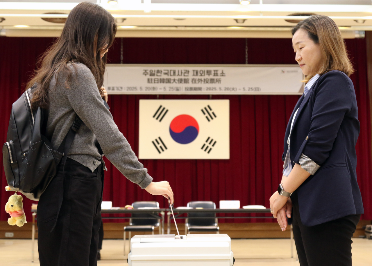A voter inserts her vote into the ballot box at a polling station set up at the Korean Embassy in Tokyo, on the first day of overseas voting, Tuesday. (Yonhap)