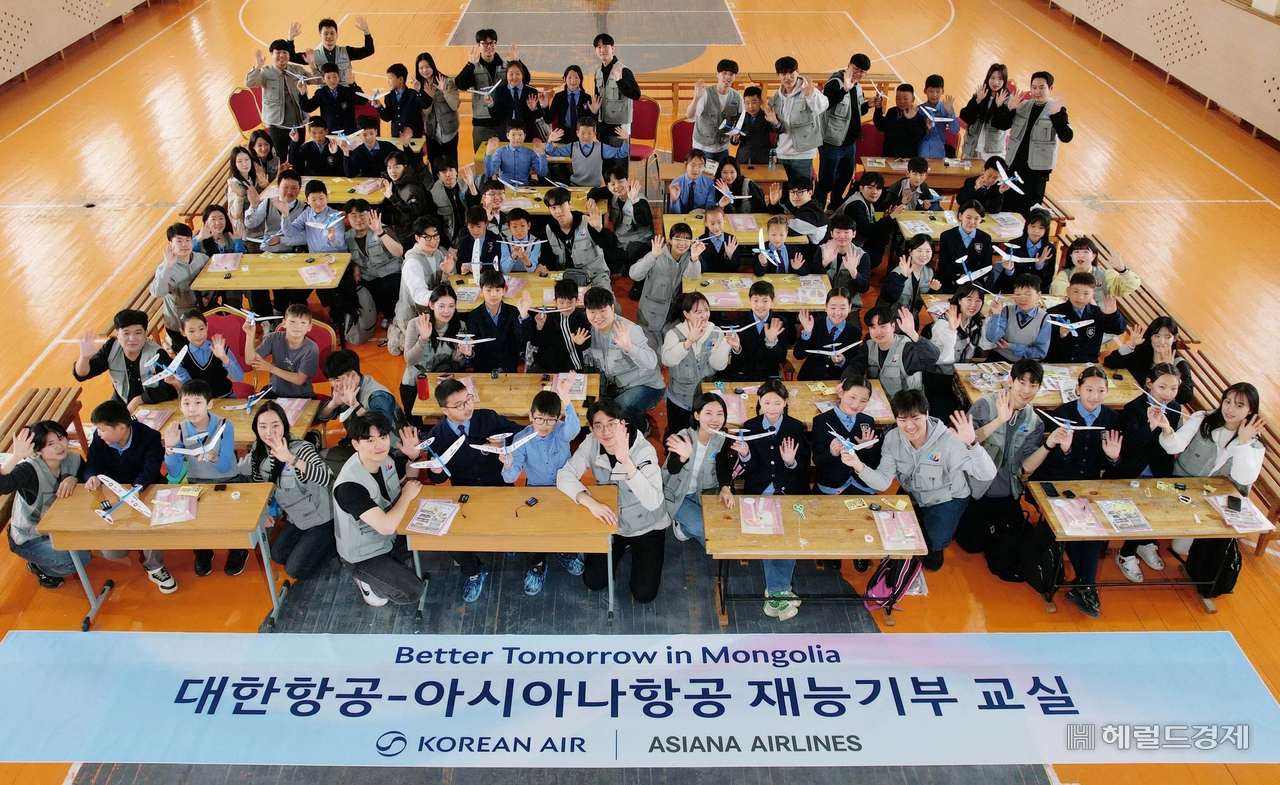 대한항공과 아시아나항공 임직원들이 21일 몽골 울란바타르시 바가노르구에 위치한 군갈루타이 국립학교에서 항공공학 체험 수업을 진행한 후 기념촬영을 하고 있다. 바가노르(몽골)=임세준 기자
