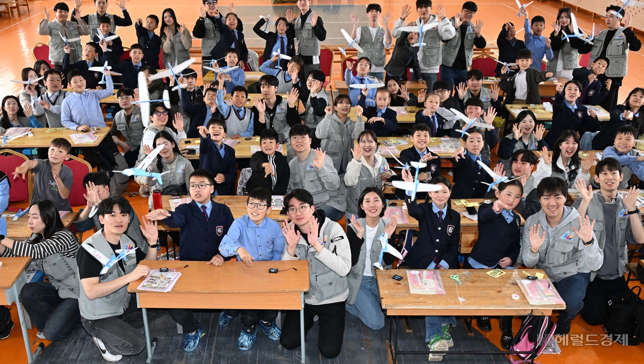 대한항공과 아시아나항공 임직원들이 21일 몽골 울란바타르시 바가노르구에 위치한 군갈루타이 국립학교에서 항공공학 체험 수업을 진행한 후 기념촬영을 하고 있다. 바가노르(몽골)=임세준 기자