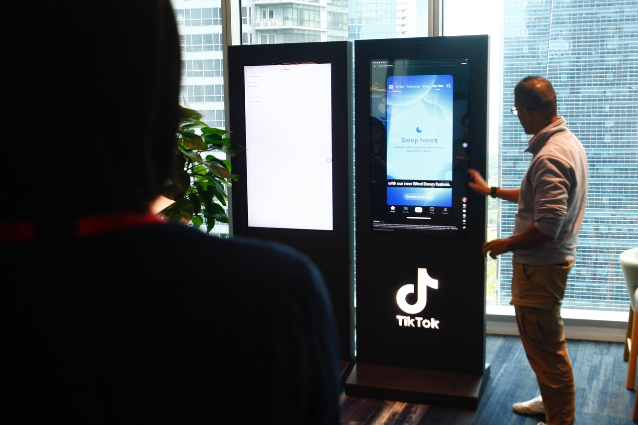 A TikTok official demonstrates the moderation process to reporters at the Transparency and Accountability Center in Singapore, May 13. (TikTok)