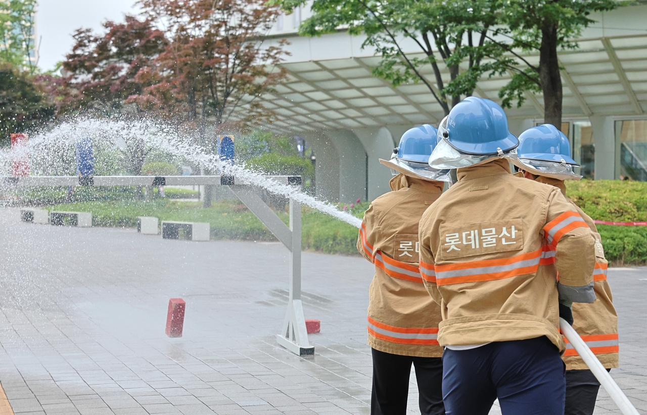 20일 서울 송파구 롯데월드타워에서 열린 ‘2025 소방경진대회’에서 참가자들이 속도방수 경연을 펼치고 있다. [롯데물산 제공]