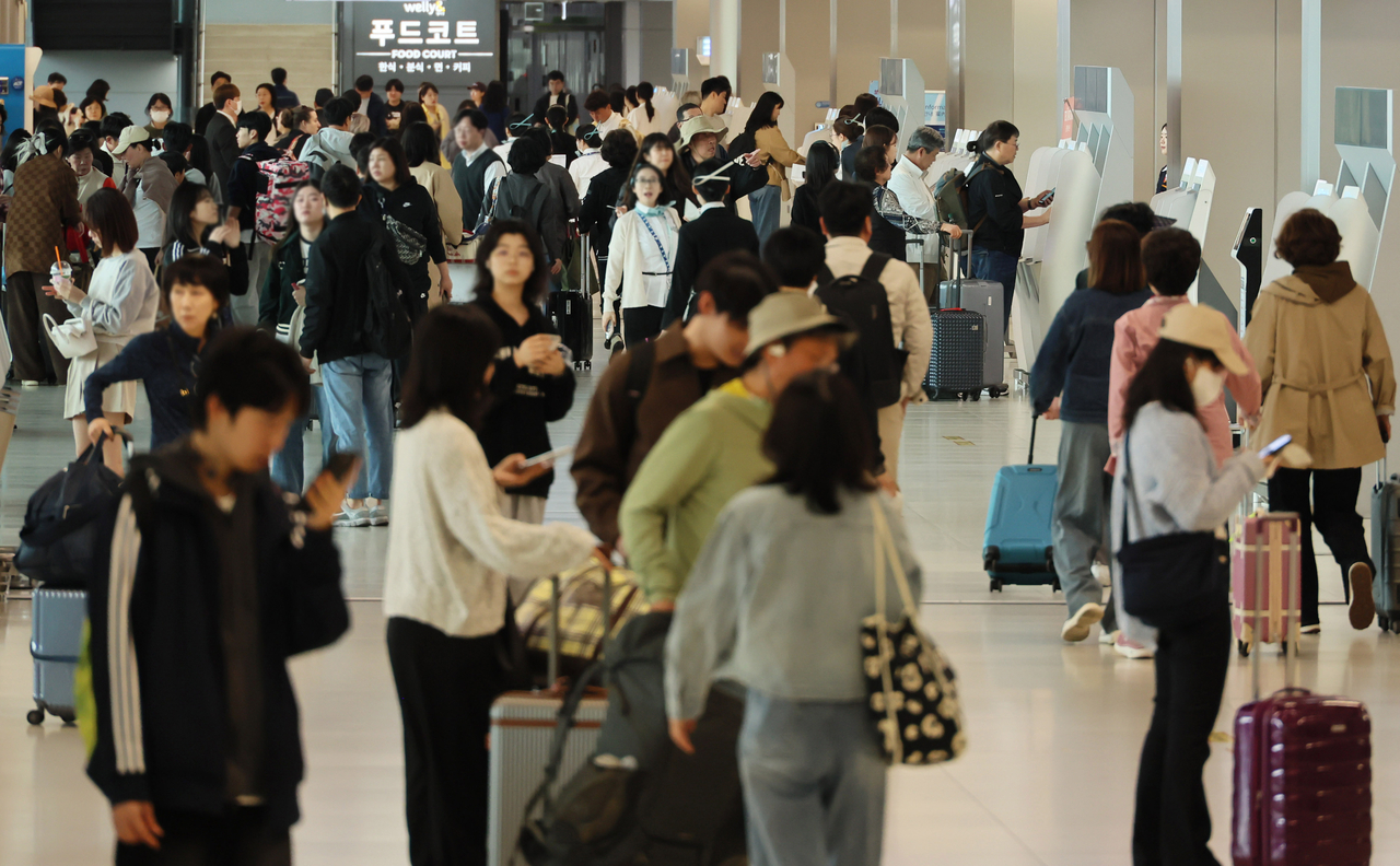 Travelers crowd Gimpo International Airport in Seoul on May 2, ahead of a long holiday weekend. (Yonhap)