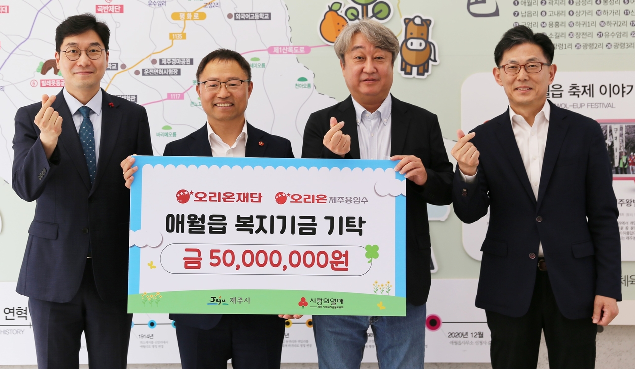 김부곤(오른쪽 첫번째) 오리온재단 이사가 지난 21일 토토사이트 계정탈퇴시 애월읍사무소에서 상생과 발전을 위한 기금을 전달하고, 기념 촬영을 하고 있다. [오리온 제공]