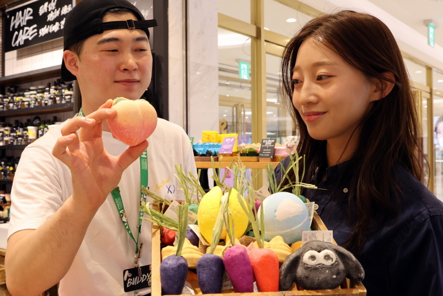 롯데백화점 대구점 지하1층 러쉬 매장에서 고객이 다양한 캐릭터 모양의 입욕제를 살펴보고 있다.[롯데백화점 제공]