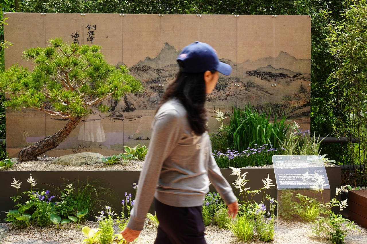 A visitor takes a quick look at Gangseo-gu's garden displayed at Seoul International Garden Show 2025 in Dongjak-gu, southwestern Seoul, Wednesday. (Lee Si-jin/The Korea Herald)