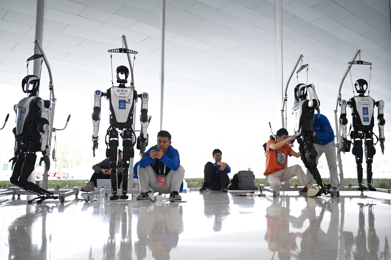 (250326) -- BEIJING, March 26, 2025 (Xinhua) -- Staff members adjust Kuavo humanoid robots at Zhongguancun International Innovation Center, venue for the 2025 Zhongguancun Forum (ZGC Forum), in Beijing, capital of China, March 26, 2025. The 2025 ZGC Forum is scheduled to be held in Beijing from March 27 to 31. Themed “New Quality Productive Forces and Global Technology Cooperation,” this year‘s annual conference of the forum comprises five major sections, including meetings and technology trading. (Xinhua/Chen Zhonghao)