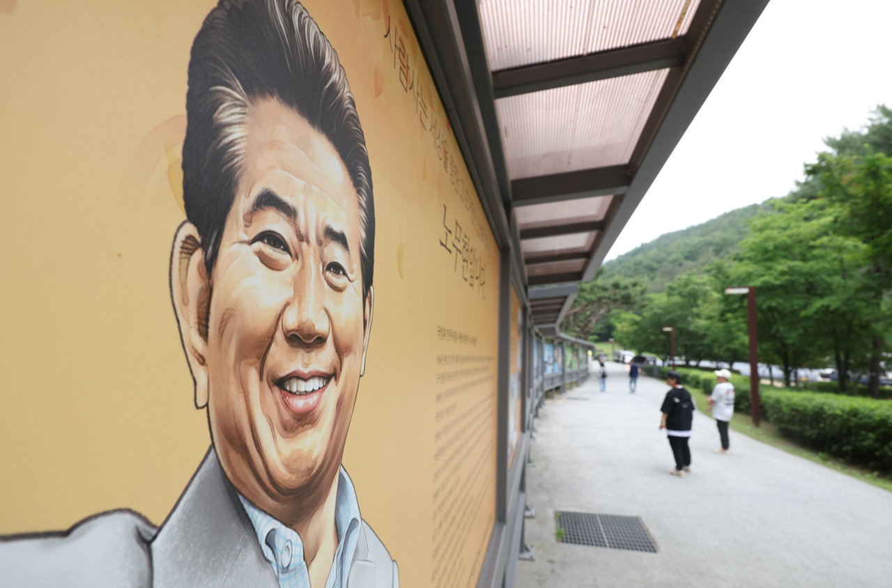 A citizen looks at a mural of late President Roh Moo-hyun in Bongha Village in Gimhae, South Gyeongsang Province, on Thursday, a day before the memorial marking the 16th anniversary of his passing. (Yonhap)
