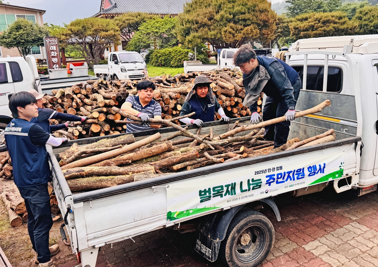 한국환경보전원 임직원과 지역주민들이 22일 전남 광양시에서 벌목재 나눔 행사를 진행하고 있다.[한국환경보전원 제공]