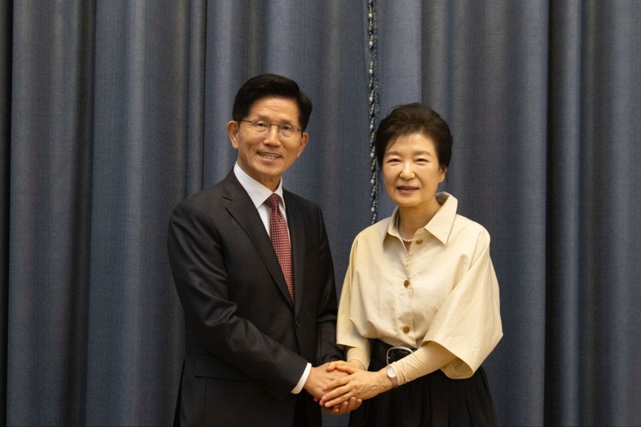 People Power Party presidential candidate Kim Moon-soo (left) poses for a photo with ex-President Park Geun-hye at Park's residence in Daegu on Saturday. (People Power Party)