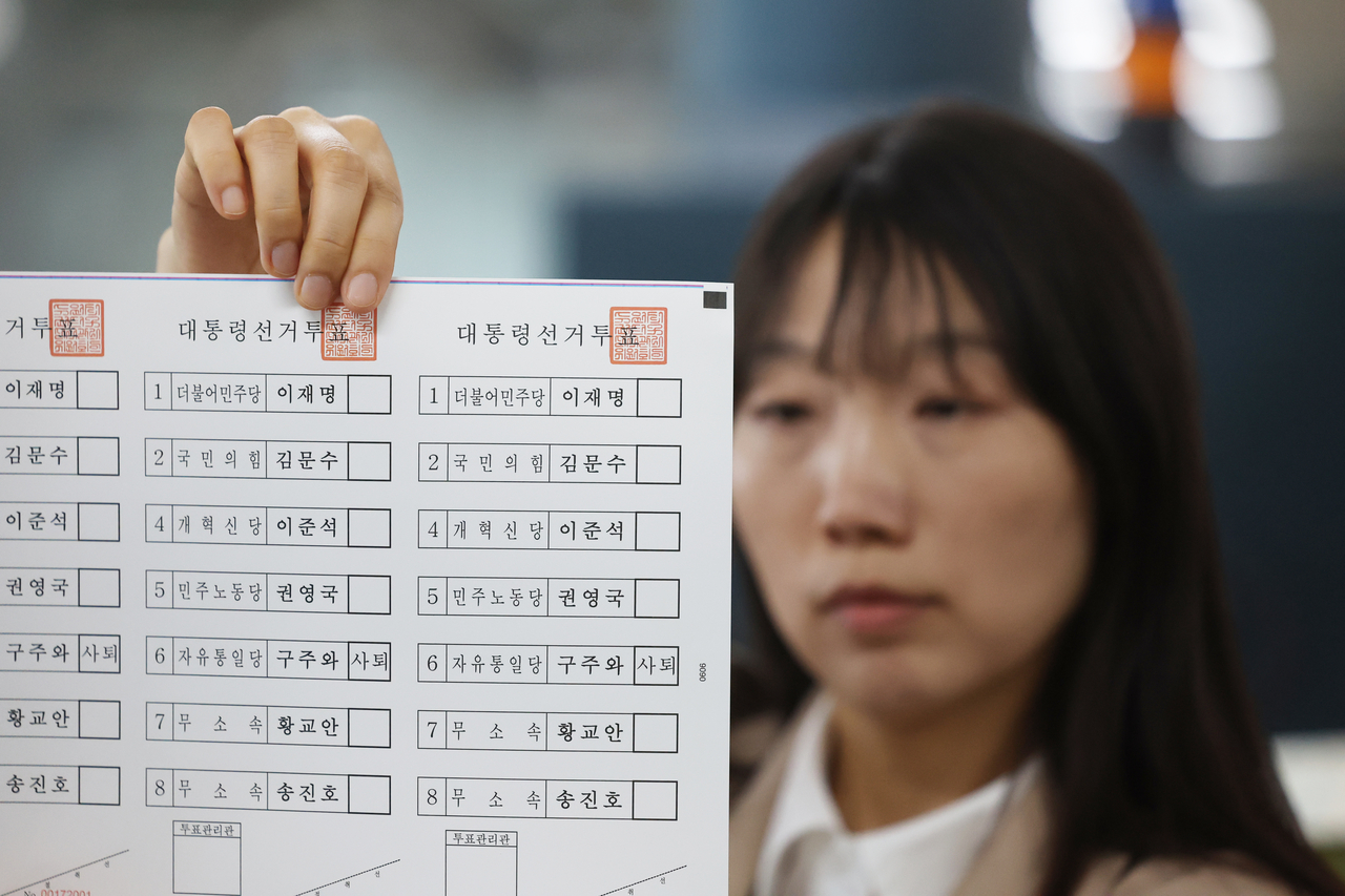 An official from the National Election Commission shows ballots for the June 3 presidential election at a printing office in Suwon, Gyeonggi Province, Sunday. (Yonhap)