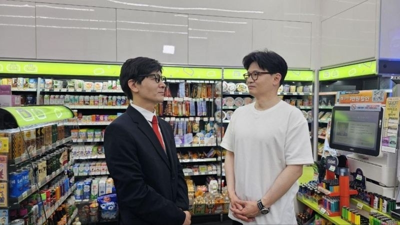 Han Dong-hoon (right), a presidential contender from the ruling People Power Party, poses with comedian Jung Sung-ho during the filming of "SNL Korea" at a convenience store set. (Courtesy of Han Dong-hoon’s Facebook)