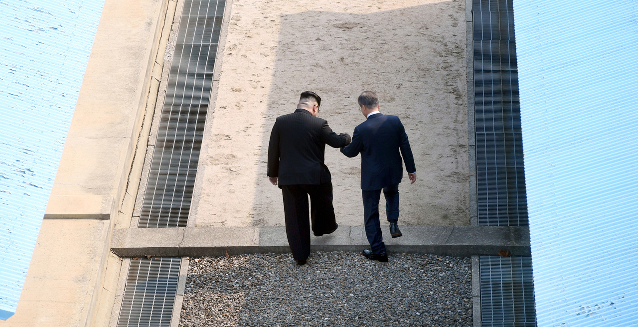 Former liberal President Moon Jae-in (right) and North Korean leader Kim Jong-un cross the Military Demarcation Line together to the north side, upon meeting for the Inter-Korean Summit April 27, 2018 in the border village of Panmunjom. (Getty Images)