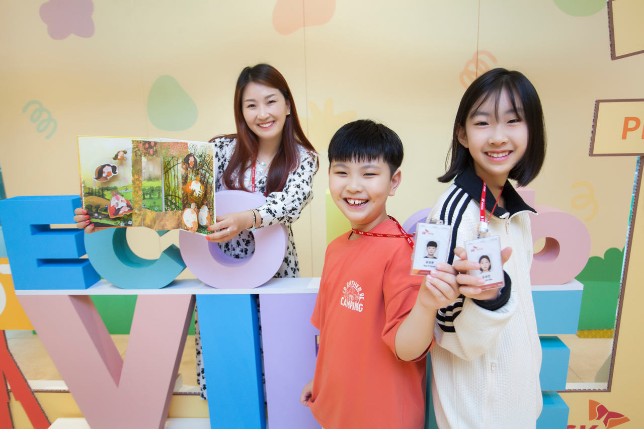 SK케미칼 구성원 토토사이트 착오이체이 명예 사원증과 봉사활동에 참여해 제작한 팝업북을 들고 기념 촬영하고 있다