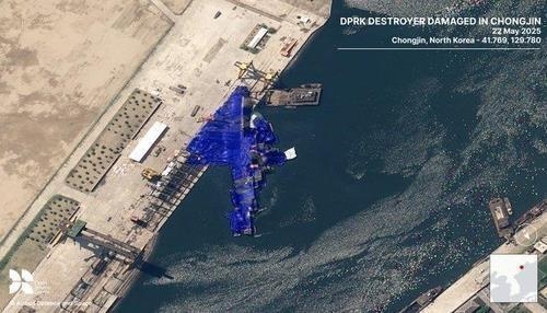 A North Korean warship lies partially submerged on its side and covered with blue tarpaulins in this commercial satellite image taken on Thursday. (London-based Open Source Centre)