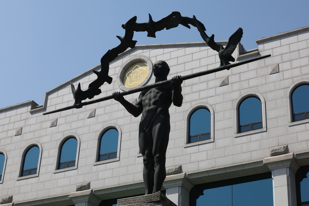 경기도 과천 중앙선거관리위원회에 설치된 ‘국토르 토토권수호자’ 동상이다. 차곡히 쌓인 투표용지 위, 하늘의 나는 비둘기 아래 ,장대를 가로잡고 완벽한 균형으로 서 있는 강인한 인체를 형상화했다. 장대를 든 사람은 안정성과 공정성·평등성을, 무지개 형상으로 나는 비둘기는 조국의 평화와 자유·희망을, 투표용지로 쌓은 단은 민의를 상징한다.  [연합]