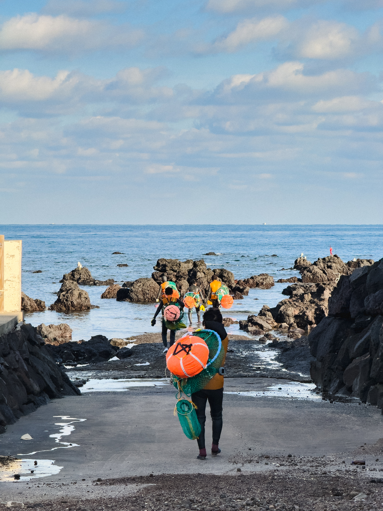 A team of haenyeo walk into the sea for a dive. (Courtesy of Lee)