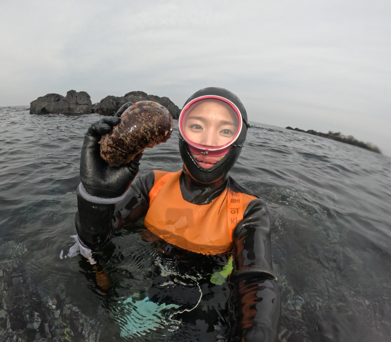 Lee takes a selfie after harvesting a mollusk from the sea. (Courtesy of Lee)