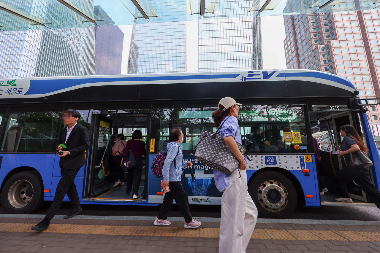 Passengers stand at the Yeouido bus transfer center in Yeongdeungpo-gu, western Seoul, Monday. (Yonhap)