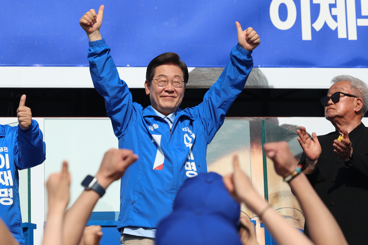 Democratic Party presidential candidate Lee Jae-myung gives a thumbs-up while appealing for public support during a campaign rally at Pyeongnae-Hopyeong Station Square in Namyangju, Gyeonggi Province, on Tuesday. (Yonhap)