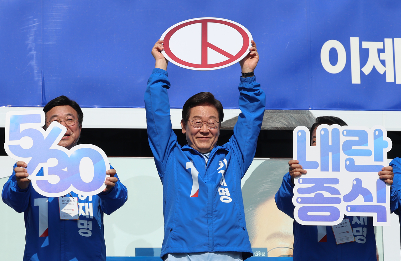 Lee Jae-myung (center), the presidential candidate of the liberal Democratic Party, encourages citizens to participate in early voting during a campaign in Namyangju, on Sunday. (Yonhap)