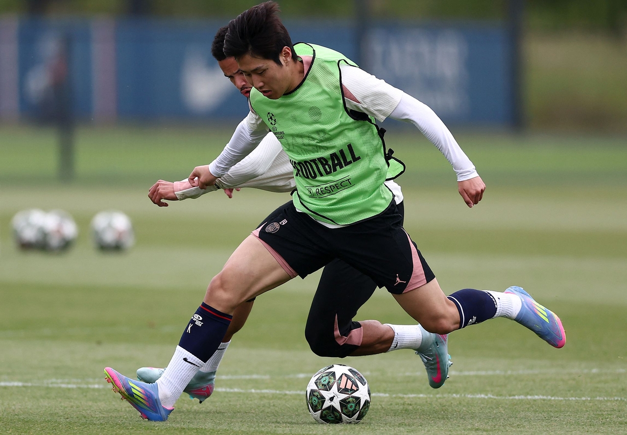 Lee Kang-in of Paris Saint-Germain battles teammate Warren Zaire-Emery for the ball during a training session ahead of the UEFA Champions League final football at the club's training camp in Poissy, France, on May 21. (AFP-Yonhap)