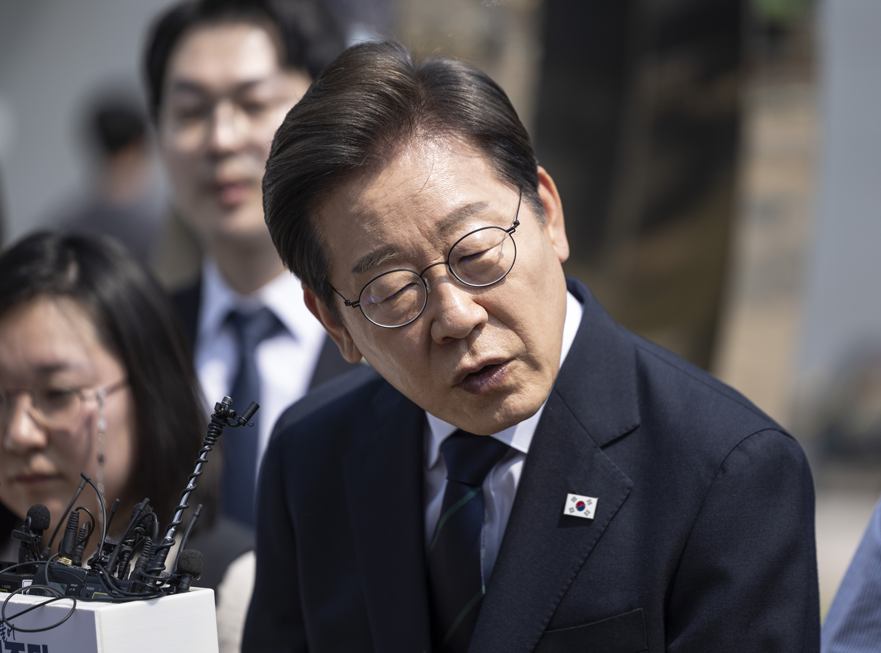 Democratic Party of Korea presidential candidate Rep. Lee Jae-myung speaks to reporters outside a polling station in Seoul on the first day of early voting on Thursday. Yonhap