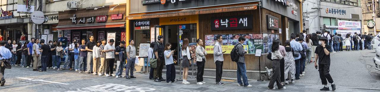 On the second and final day of early voting, a long line of voters stretches into the street near Sogong-dong Community Center in Jongno, Seoul, on Friday. (Yonhap)