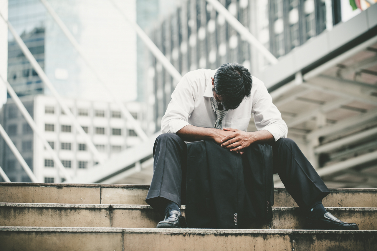 A man sits alone on a city stairwell. (123rf)
