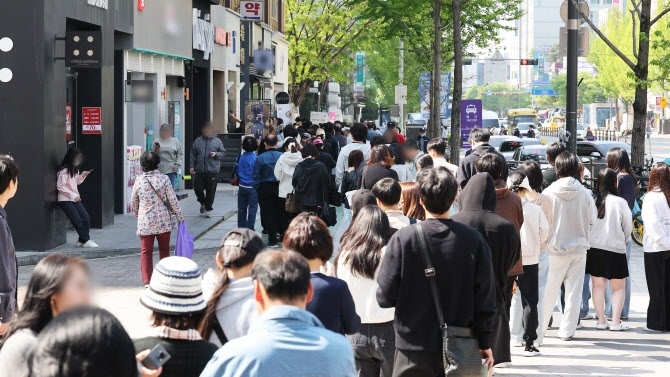 SK텔레콤 해킹 스포츠토토로 고객 이탈이 가속화되면서, 고객 유치를  위한 통신 3사 간의 과열 경쟁이 극심해지고 있다. SKT 대리점 앞에서 유심을 교체하려고 시민들이 줄을 서 기다리는 모습. [연합]