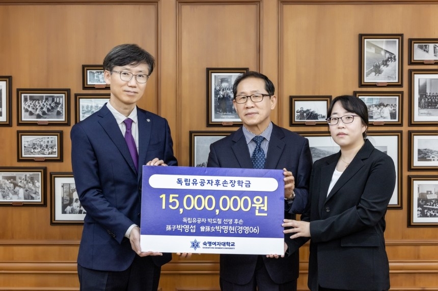 This photo distributed by Sookmyung Women's University shows Park Yeong-seob (center) and Park Myung-hyun (right) posing for a photo after making a donation to fund a scholarship at the school. Park Yeong-seob is the grandson of freedom fighter Park Do-chul, and Park Myung-hyun is his great-granddaughter. (Sookmyung Women's University)