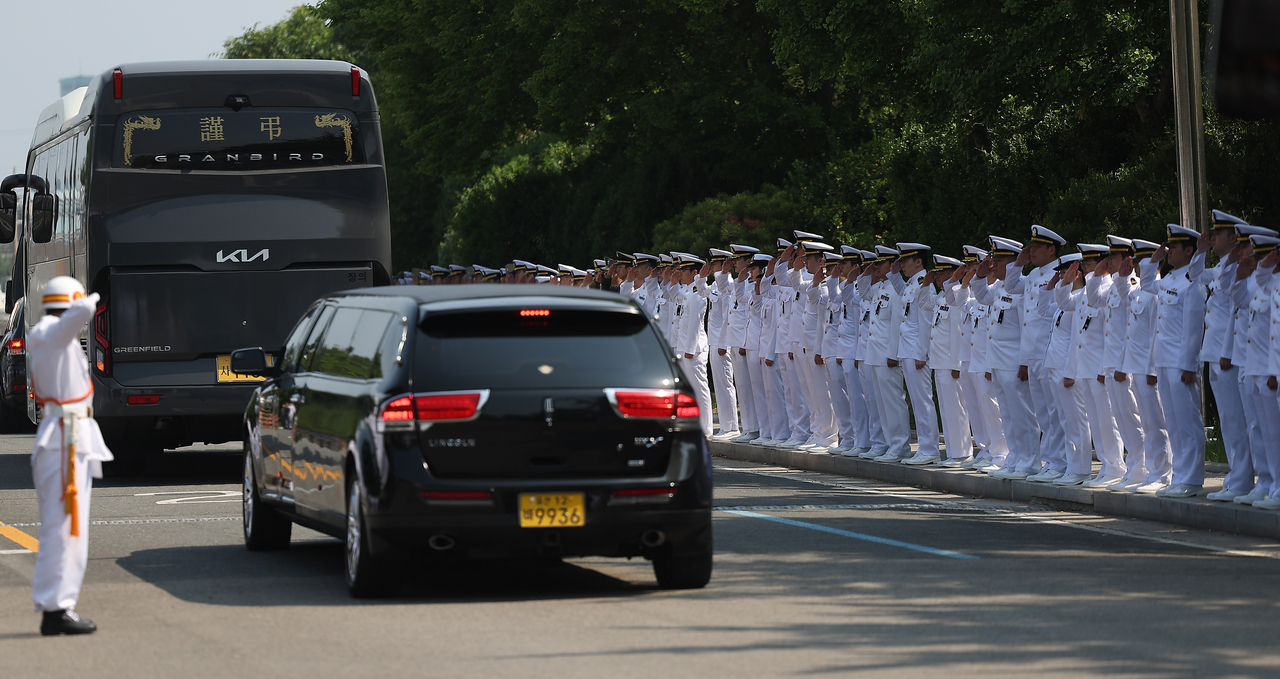 Sailors stand in formation and offer a final salute as the funeral procession for the P-3CK crash victims exits the Naval Air Command grounds in Pohang, North Gyeongsang Province, Sunday. (Yonhap)