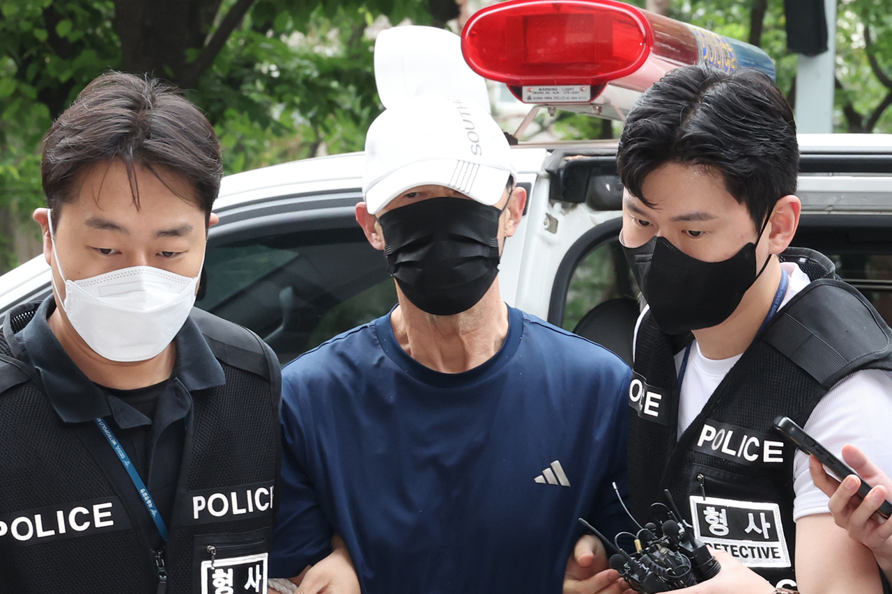 A subway arson suspect (center) arrives at the Seoul Southern District Court on Monday to attend his arrest warrant hearing. (Yonhap)