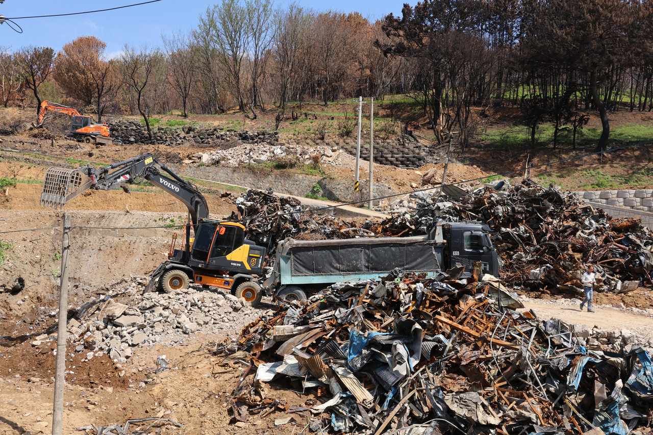 This May 7 photo taken in Yeongdeok-gun, North Gyeongsang Province, shows workers cleaning up rubble from a home destroyed in the March wildfires, which ravaged the country's southeastern region. (Yonhap)