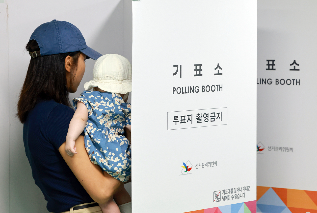 21대 대통령 선거 사전888토토 둘째날인 지난달 30일 서울 관악구 낙성대동주민센터에 마련된 낙성대동사전888토토소에서 아이를 안은 유권자가 888토토하고 있다. 사진은 기사 내용과 직접적 관련 없음. [연합]