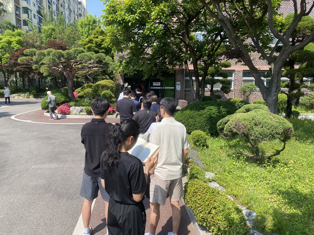 People wait in line to vote at a high school in Apgujeong-dong, southern Seoul, Tuesday. (Lim Jae-seong/The Korea Herald)