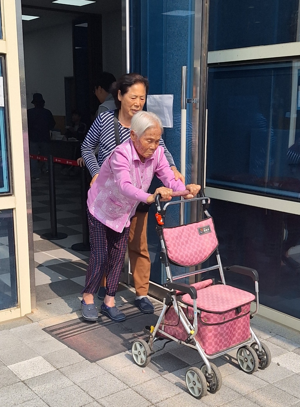 Lee Yong-geum, registered as a 121-years-old, exits a polling station set up in Okcheon-gun, North Chungcheong Province, with her daughter, after participating in Tuesday's presidential election. (Yonhap)
