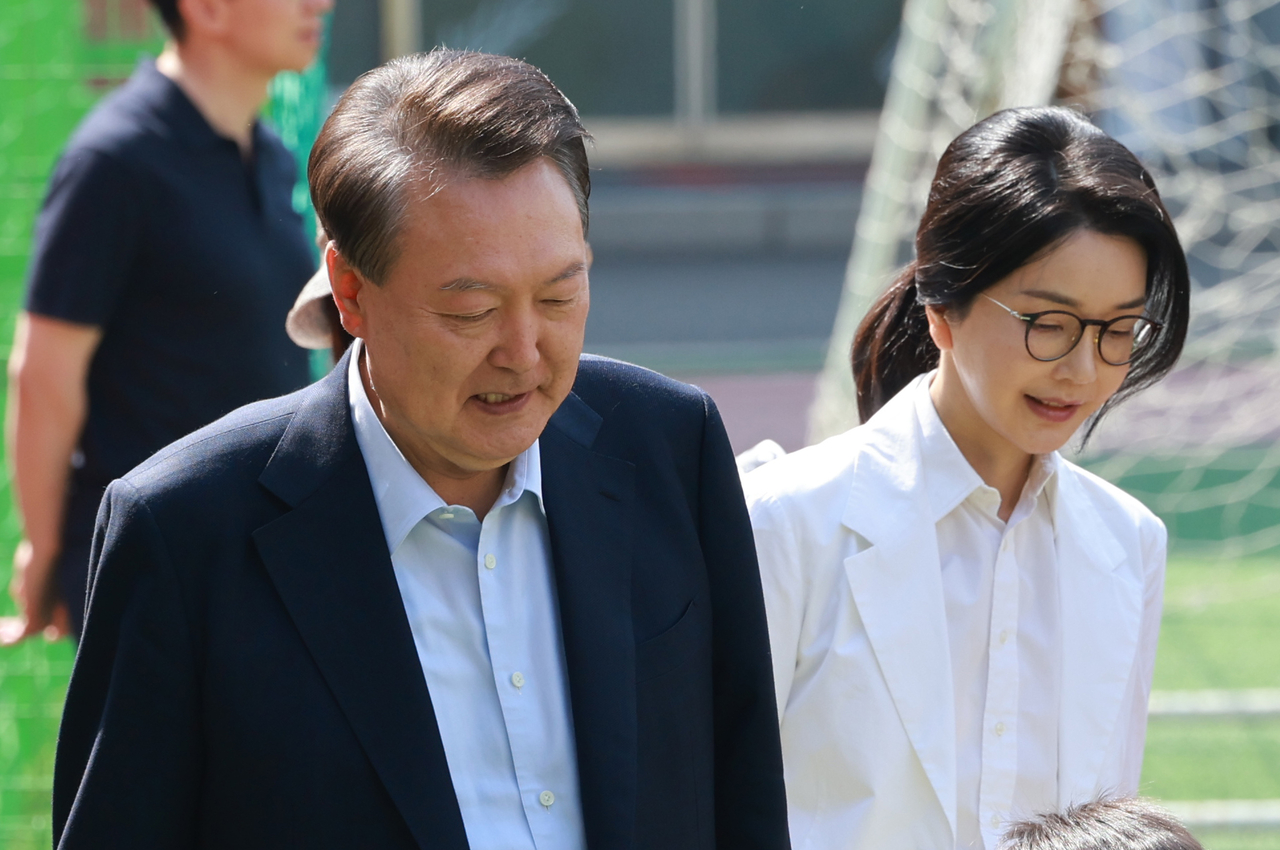 Former President Yoon Suk Yeol (left) and his wife Kim Keon Hee arrive at a polling station in Seocho-gu, southern Seoul, Tuesday. (Yonhap)