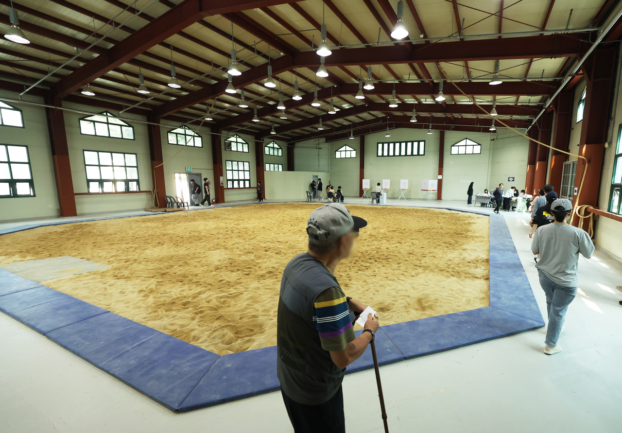 Voters cast their ballots on Tuesday at a polling station set up inside the indoor ssireum wrestling arena at Seongnam Sports Complex in Gyeonggi Province. (Yonhap)