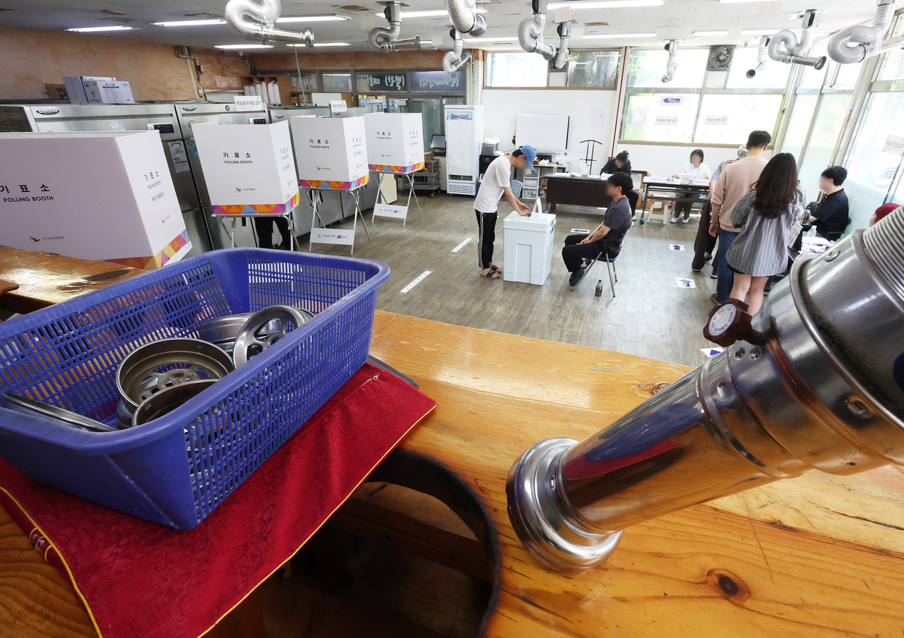 Voters cast their ballots on Tuesday at  a polling station set up inside a Korean barbecue restaurant in Gyeonggi Province. (Yonhap)