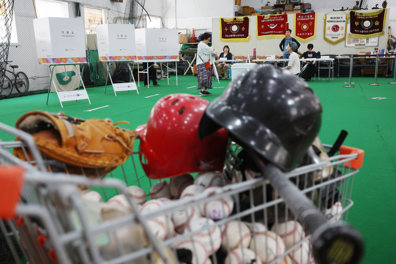 A voter casts a ballot on Tuesday at a polling station set up inside the indoor training facility of an elementary school baseball team in Seoul. (Yonhap)