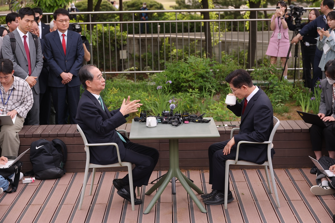Presidential candidate Kim Moon-soo of the People Power Party (right) meets with then-independent contender Han Duck-soo at a cafe on the National Assembly grounds in Seoul on May 8 to discuss a potential merger of their candidacies that was ultimately called off. (Yonhap)