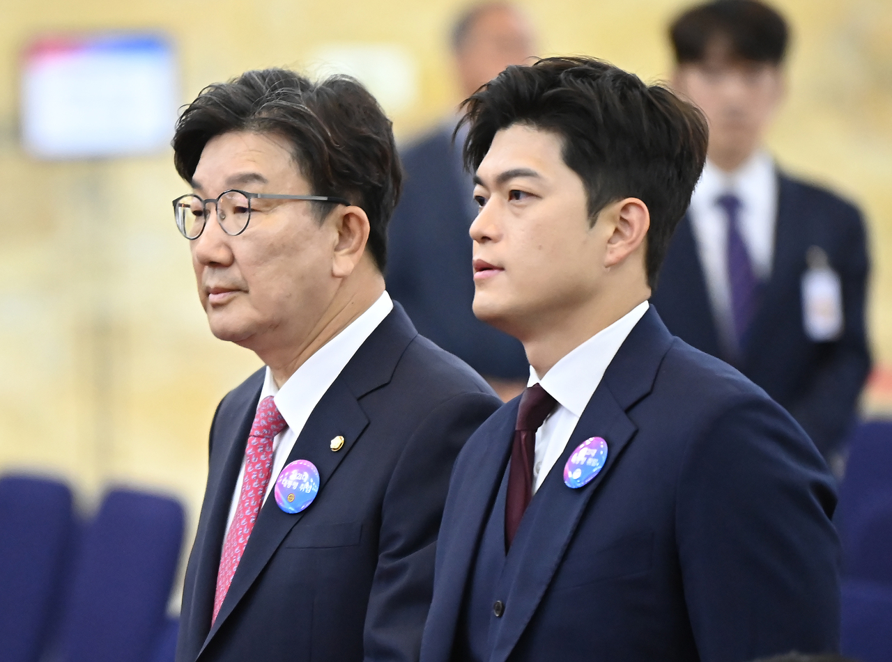 People Power Party interim leader Kim Yong-tae (right) stands next to the party's Floor Leader Kweon Seong-dong during the swearing-in ceremony for President Lee Jae-myung, at the National Assembly on Wednesday. (Yonhap)